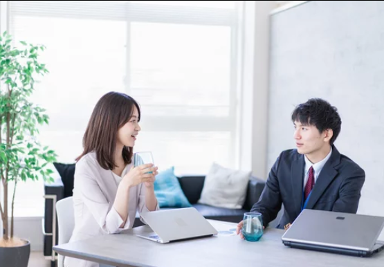 会議で自然に笑う若手社員