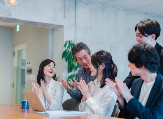 成果を上げた仲間に拍手を送る社員たち